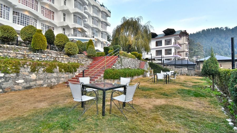 Lawn area with seating arrangements in front of the DLS Hillcrest Resort, Shimla
