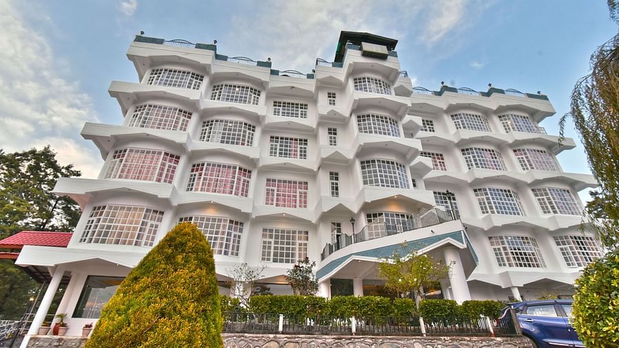 Facade of DLS Hillcrest Resort, Shimla, showcasing the exterior with a lush garden at the front.