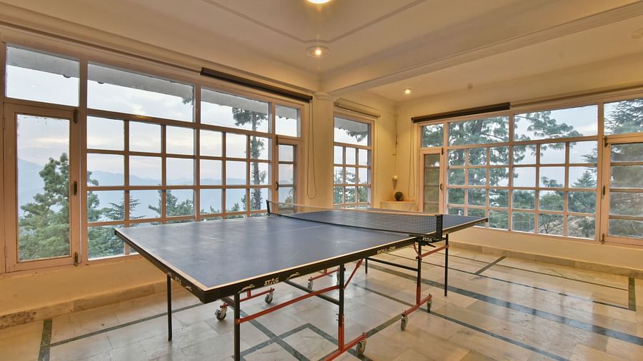 A spacious table tennis area with multiple windows welcoming plenty of natural light at DLS Hillcrest Resort, Shimla.