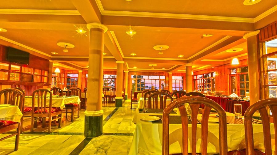 restaurant interior featuring tall pillars with seating arrangements at DLS Hillcrest Resort, Shimla