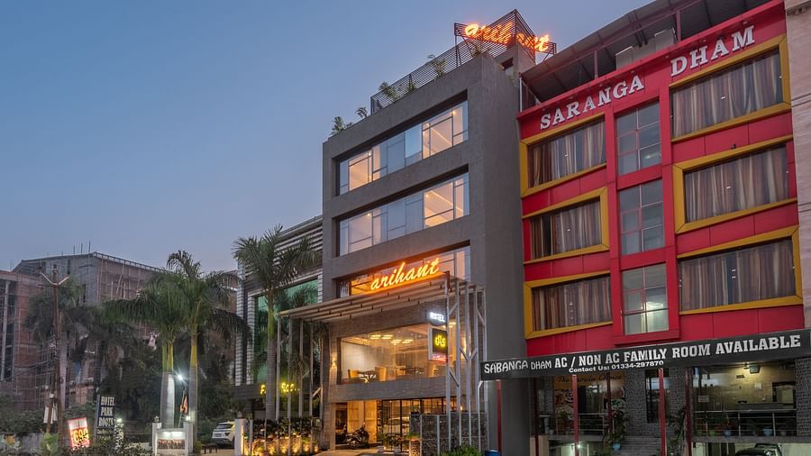 Facade image of DLS Hotel Arihant, Haridwar with trees and blue sky in the background 