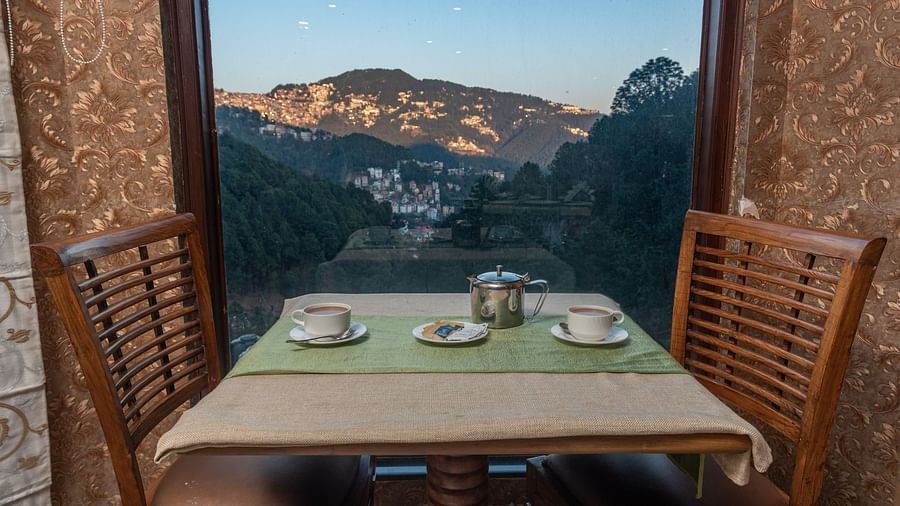 Dining space with a mountain view through the window at DLS Hotels The Rock Castle.