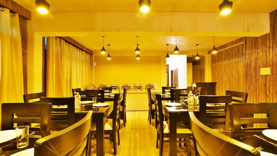 An image of the woodden tables and chairs in the restaurant of the resort | DLS Kapoor Resort Manali