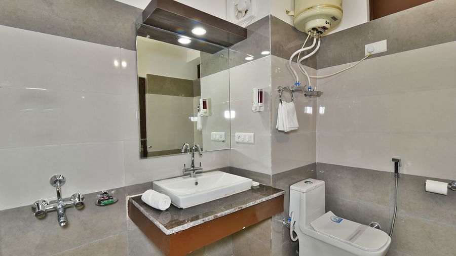 Image of a well equipped washroom featuring a wash basin and a commode | DLS Kapoor Resort Manali