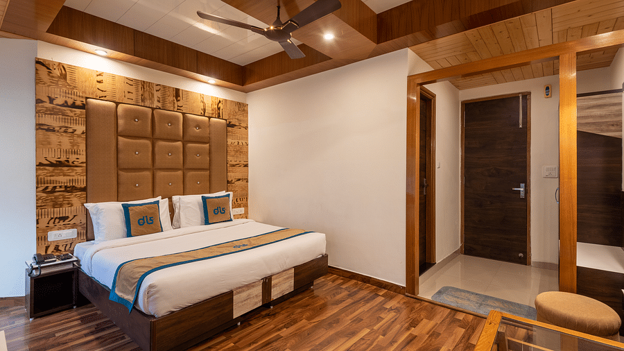 A premium room with modern decor, wooden accents, a comfortable bed, and a warm ambience, featuring essential amenities for a relaxing stay - DLS Meghavan Resort, Dharamshala