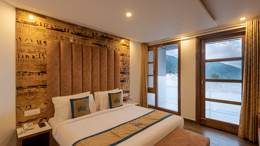 Premium room with a bed, wooden decor, TV, and a balcony offering mountain views - DLS Meghavan Resort, Dharamshala