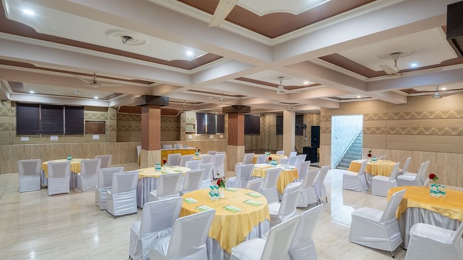 A banquet hall with decorated tables and chairs at DLS Park Grace, Haridwar.