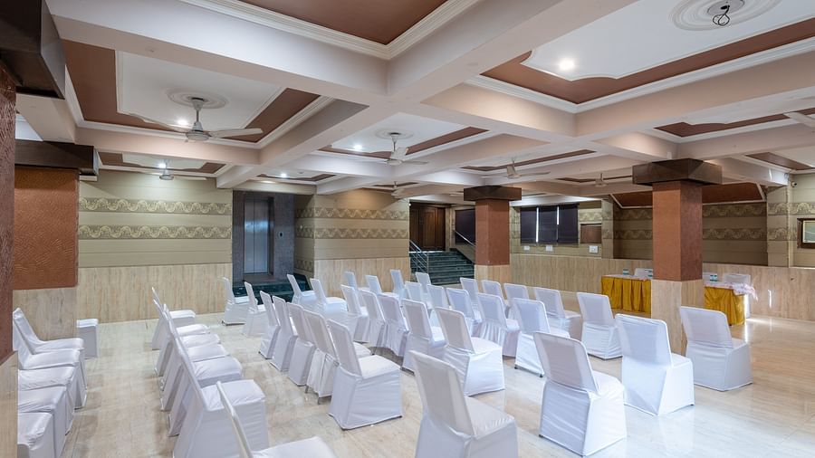 Side view of a banquet hall with chairs covered in cloth at DLS Park Grace, Haridwar.