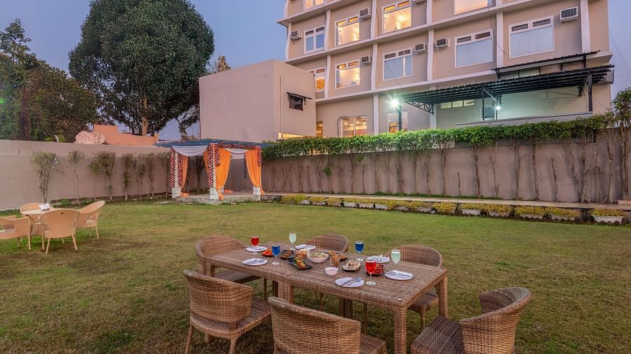 Lawn area at DLS Park Grace, Haridwar featuring multi storey building, seating area and beautiful green lawn.