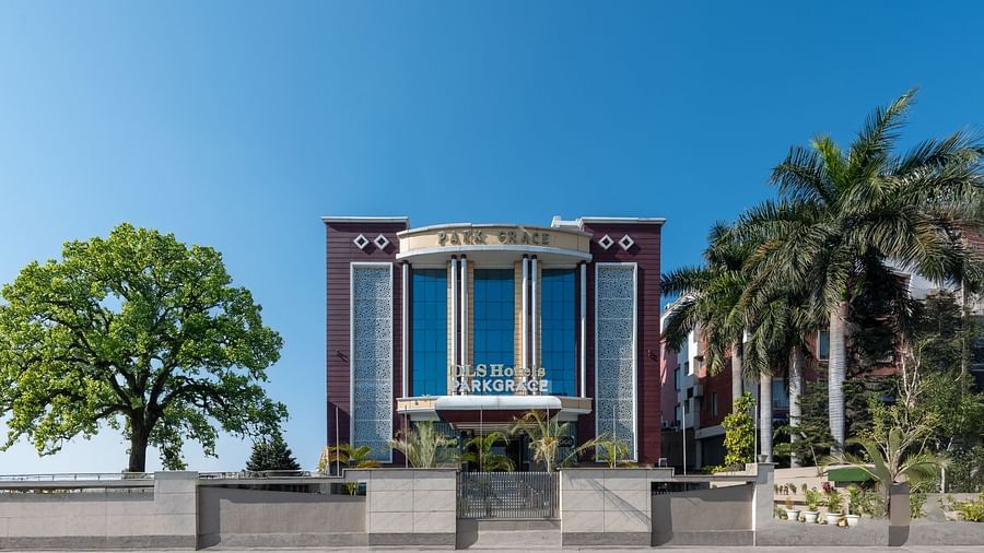  The exterior of DLS Park Grace, Haridwar featuring tall multi storey building, covered with trees.