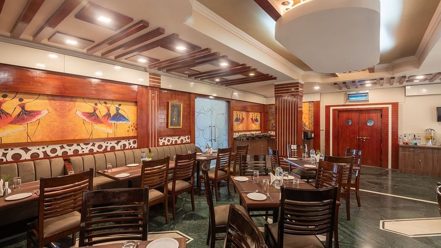 Dining area with colourful paintings on the side walls at DLS Park Grace, Haridwar.