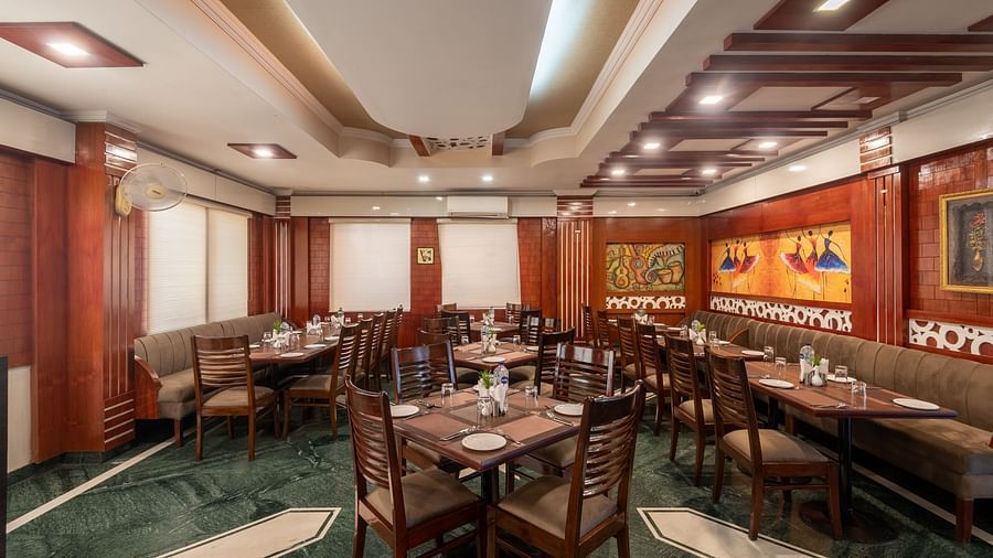 Dining area at DLS Park Grace, Haridwar featuring wooden furniture, and ample seating area.