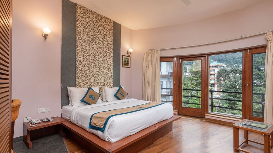 A Luxury Cottage at DLS Spring Valley Resort Dharamshala featuring a king size bed, table and a big balcony