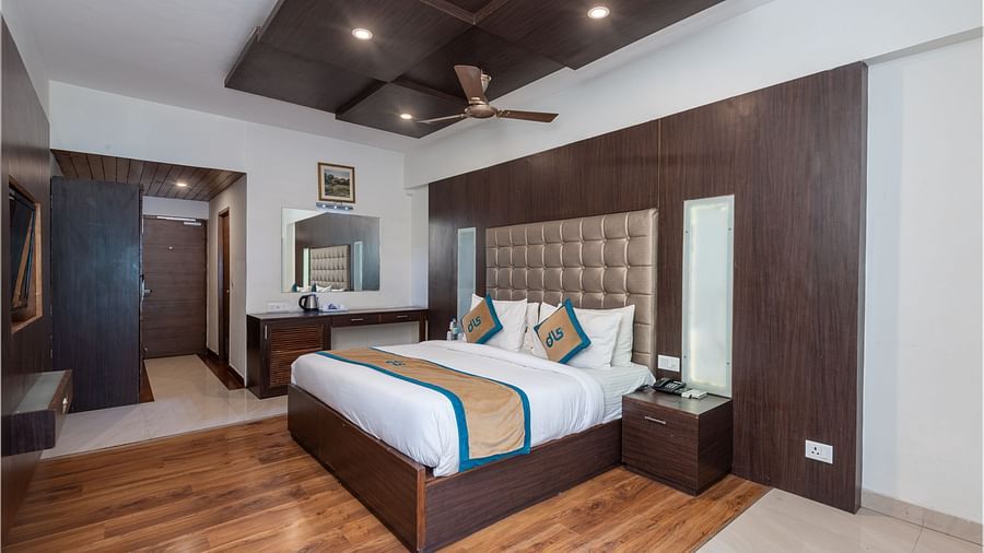 Overview of Premium Room at DLS Spring Valley Resort Dharamshala featuring a king size bed, TV and a chair