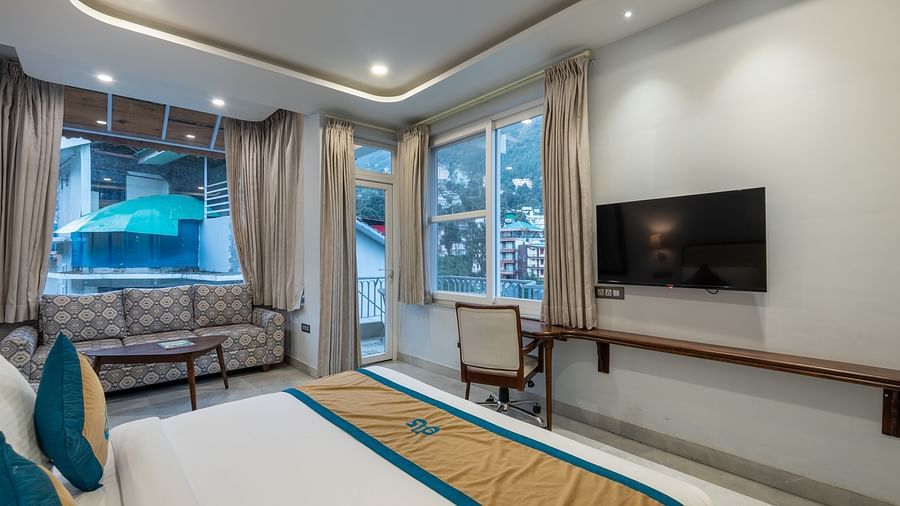 Spring Suite at DLS Spring Valley Resort Dharamshala featuring a kind bed, work desk and chair, TV, sofa and a huge balcony