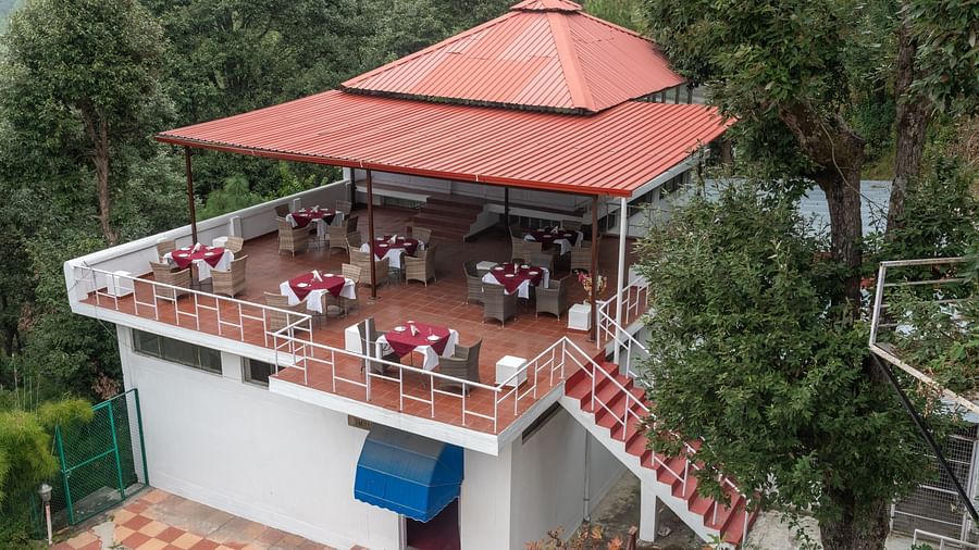 A charming outdoor restaurant at DLS Tehri Club Resort with a scenic view of the surrounding hills.