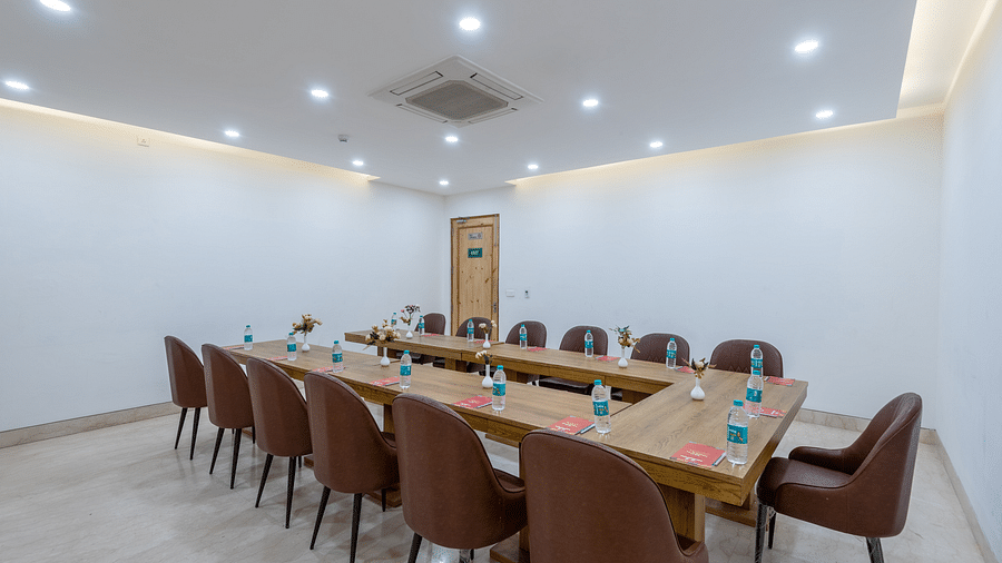 Side view of a conference room with multiple chairs, an air conditioner, and water bottles placed on the table at DLS The Classio