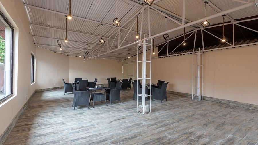 Shot of an empty conference hall with few chairs and tables kept around  | DLS The Pearl