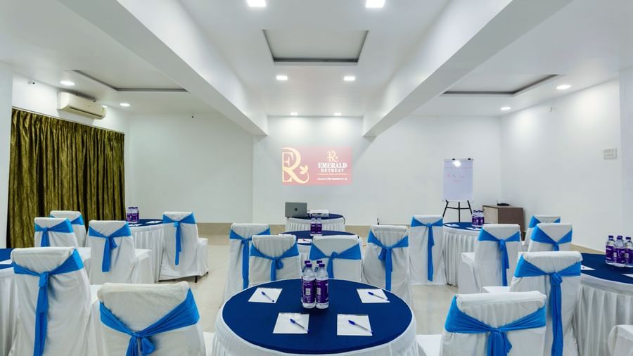 Round table with a cluster seating arrangement with blue accents at Emerald Retreat, Tungarli.
