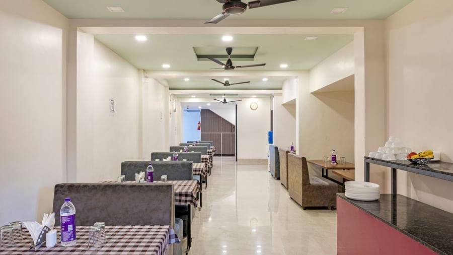 Spacious dining hall with ceiling fans and warm lighting at Emerald Retreat, Tungarli.