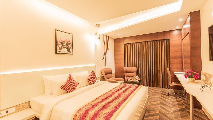 a comfy bed at Club Room featuring a red and yellow blanket and pillow at Hotel Park Elanza, Coimbatore