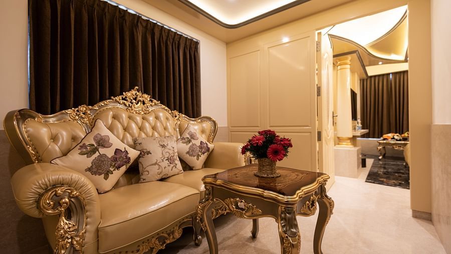 Lavish sofa and a table decorated with a vase of roses at King Suite in Hotel Park Elanza, Coimbatore