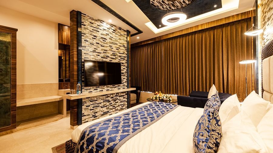 Queen suite decked with a bed and television at Hotel Park Elanza, Coimbatore