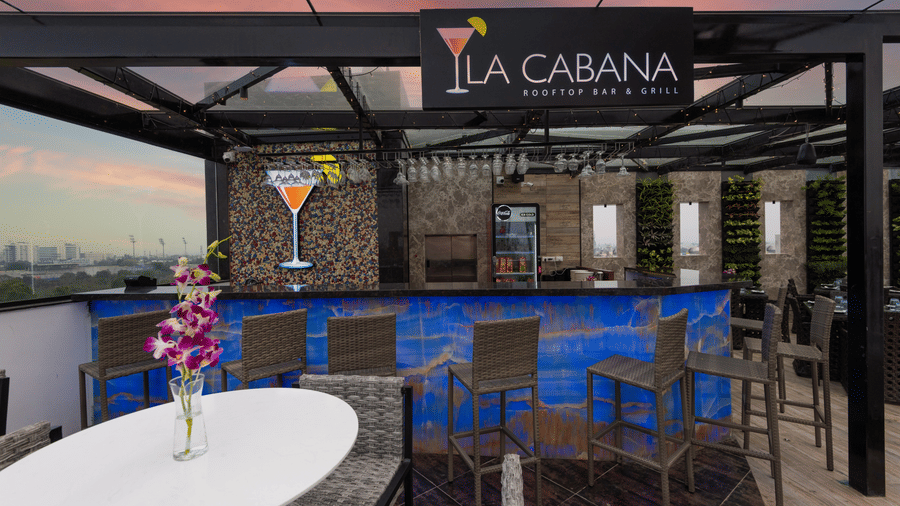 La cabana restaurant at Hotel Park Elanza Coimbatore, with aligned tables and chairs in a rooftop setting.