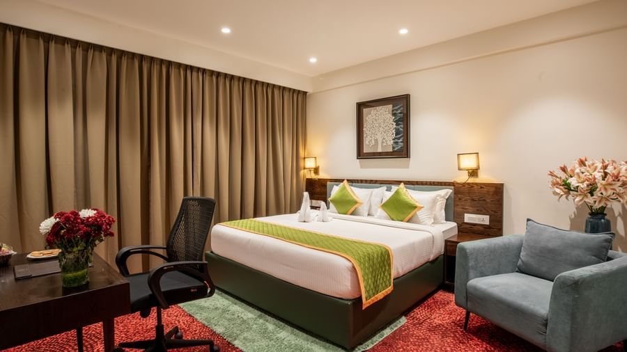 Elegant room with king size bed, seating area, and modern decor at Hotel Royal Regency Chennai