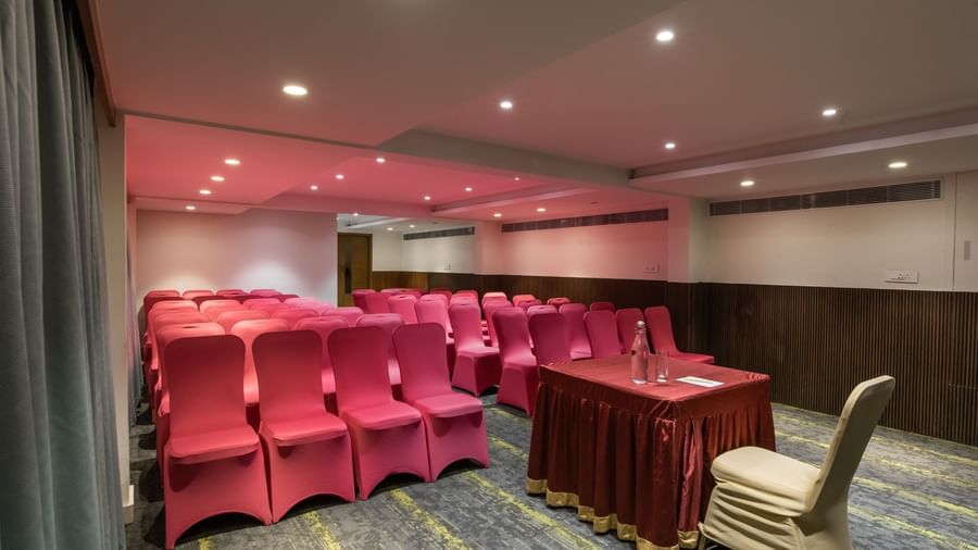 Event space with boardroom-style setup and red chairs at Hotel Royal Regency Chennai