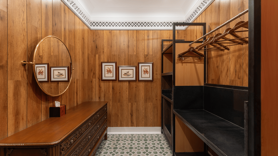 Walk-in closet dressing area with wooden wardrobe racks and mirror at Mayfair Manor, Jungpana.