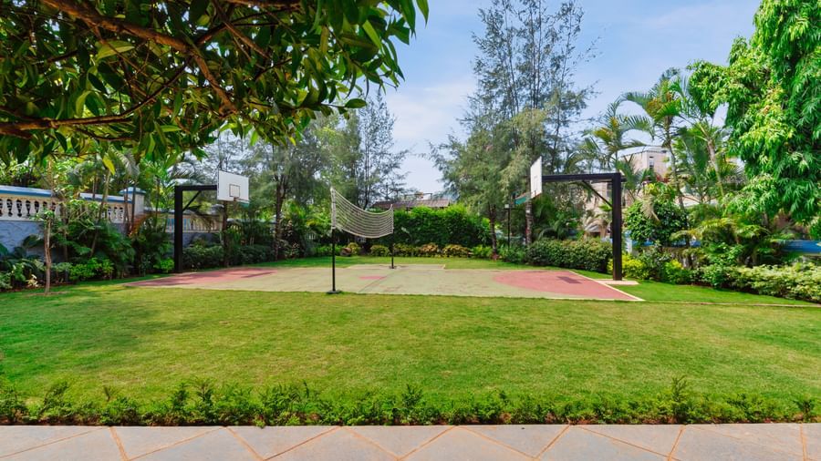 Front view of volleyball and basketball area surrounded by trees at Mayur Retreat.
