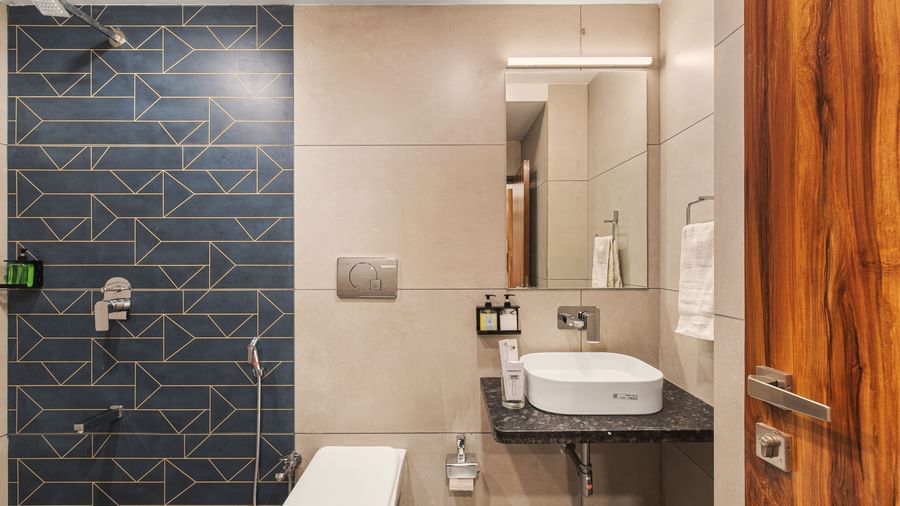Contemporary toilet and wash area at Mayur Retreat with dark feature wall and sleek fixtures.