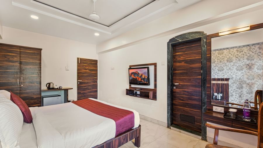 King size bed room at Mayur Retreat with wooden decor and warm ambient lighting.