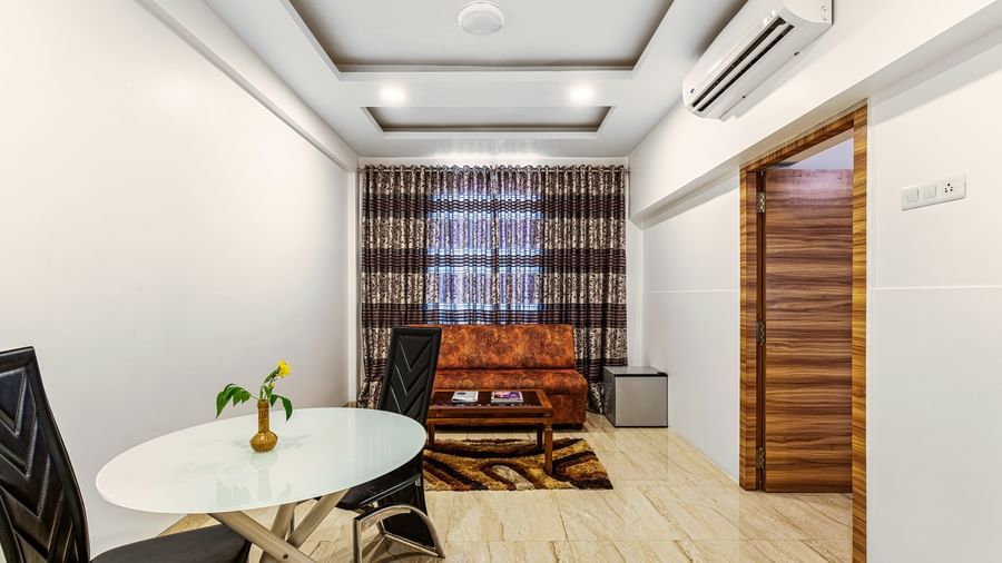 Compact meeting or dining area inside Mayur Retreat, with minimalist decor and seating for four.