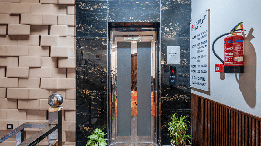 Lift at DLS Hotels On The Ganges with potted plants and a fire extinguisher.