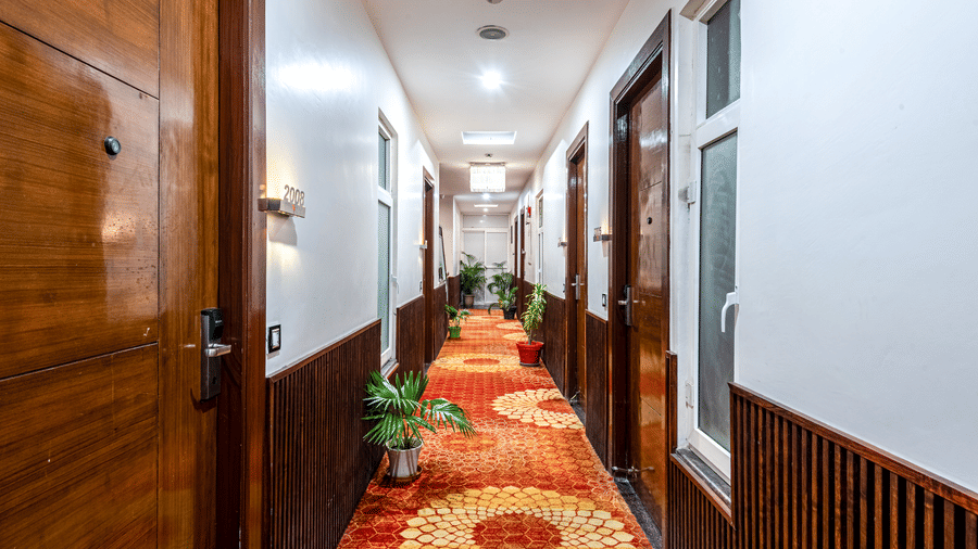 Corridor at DLS Hotels On The Ganges with orange decorative carpet.