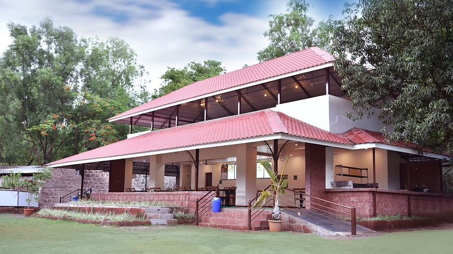 A side view of the restaurant facade at Riverside Inn, surrounded by plants and trees.