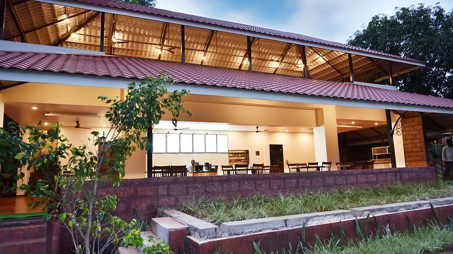 A close-up view of the restaurant facade at Riverside Inn, with plants beside the trail leading to the entrance.