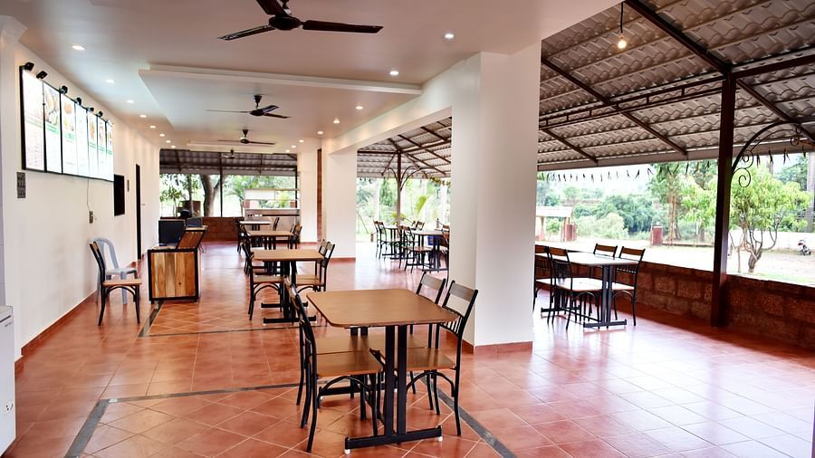 An interior view of the restaurant at Riverside Inn, featuring neatly arranged tables and chairs, with a ceiling fan overhead.