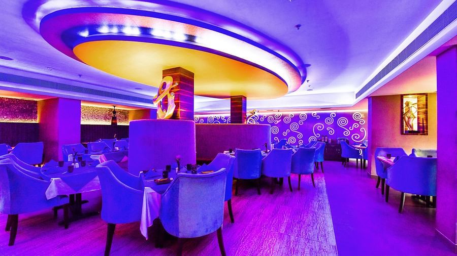 Image of Aqua Restaurant with sofa and a huge fancy light above it at Swosti Grand, Bhubaneswar