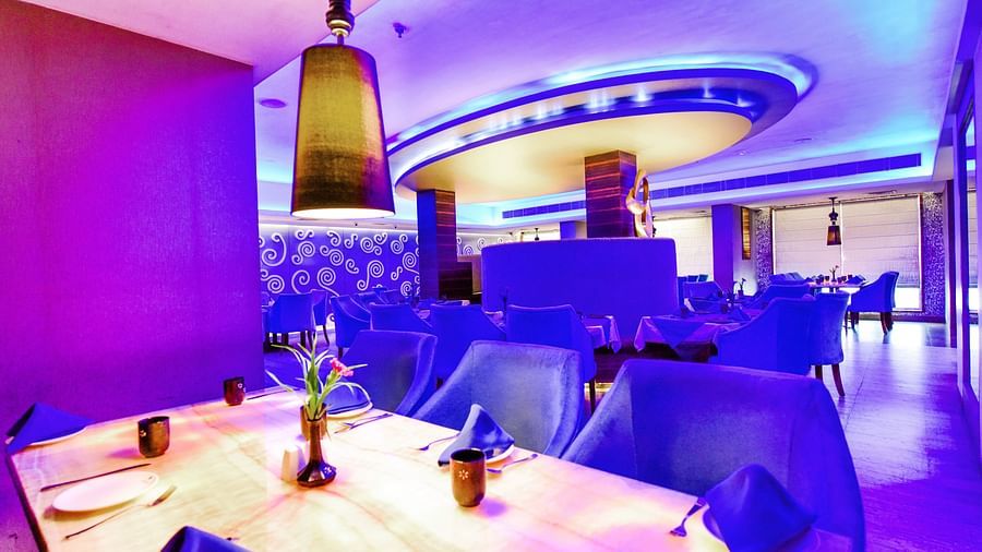 Aqua Restaurant with dining area and light hanging above it at Swosti Grand, Bhubaneswar