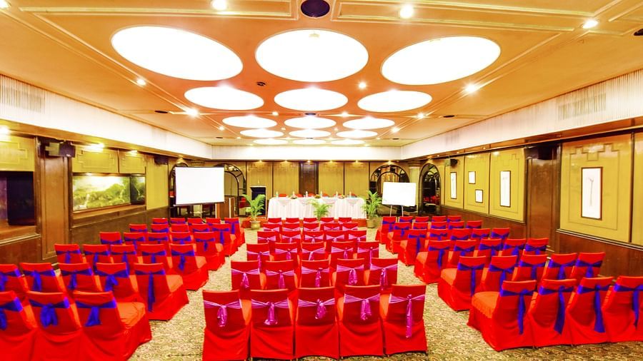 Image of a banquet hall with chairs arranged and a fancy lighting on the ceiling at Swosti Grand, Bhubaneswar