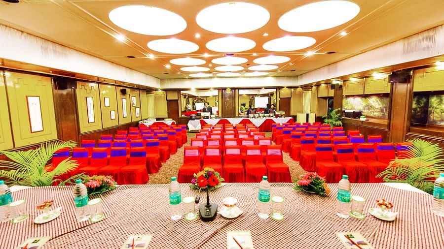 Image of a banquet hall with a table on the pulpit and chairs arranged in front at Swosti Grand, Bhubaneswar