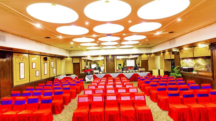 Image of a banquet hall with chairs arranged and a fancy lighting on the ceiling at Swosti Grand, Bhubaneswar