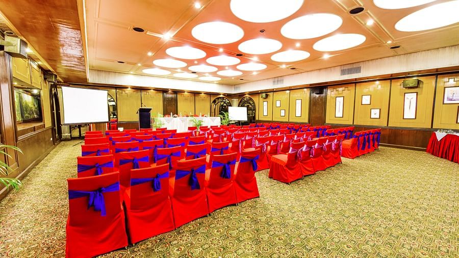 Back view of a banquet hall with chairs arranged and a fancy lighting on the ceiling at Swosti Grand, Bhubaneswar