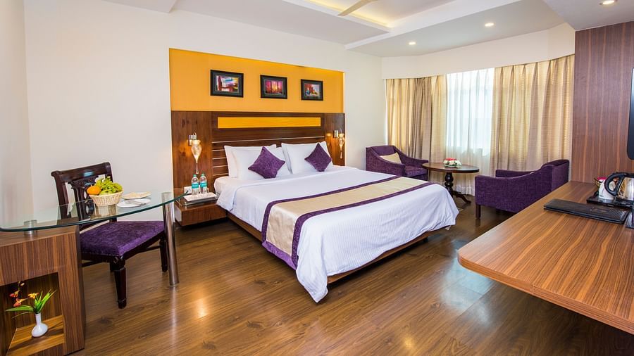Grand Room with bed, table and seating area at Swosti Grand, Bhubaneswar