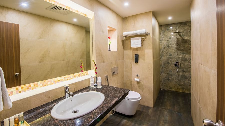 Grand Room washroom with basin and modern amenities at  Swosti Grand, Bhubaneswar