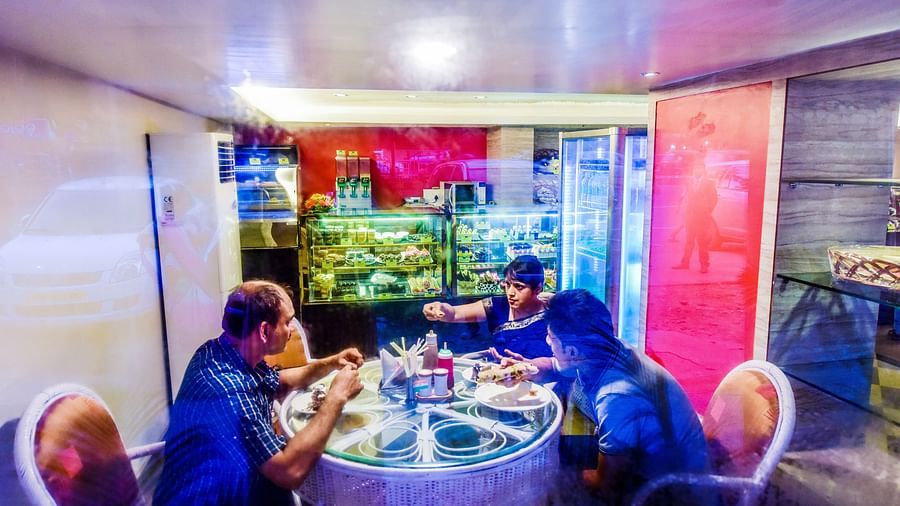 Image of a restaurant with guests sitting and eating food at Swosti Grand, Bhubaneswar