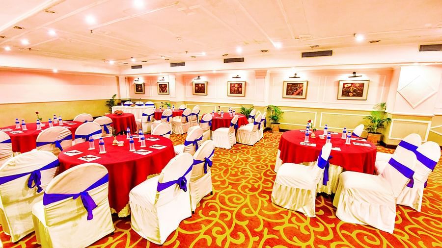Well-lit banquet hall, with comprehensive decorations, ready to host a festive event.